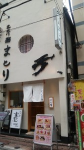 CDATA[
江戸前寿司♪
本日所用で外出した帰り、大門(浅草線新橋駅隣)のこじゃれたお寿司屋さんで、一人ランチをしてきました。白木のカウンターでお寿司を頂くのは久しぶりで、板さんの手さばきを見ていたのですが、桶の中の酢飯が赤いので話しかけてみました。
私「ここのシャリは【赤酢】なんですね」
板「今流行りですからね~昔は二番煎じの庶民のお酢だったんんですけどね~今じゃ3倍の高級酢ですよ」
お酢といえば、われらが日本福祉大学のキャンパスがある知多半島の半田市に、本社を構える全国区の企業「ミツカン」(株式会社Mitsukan Holdings)・・・そこで思わず聞いてしまいました。
私「使ってるのはもしかしてミツカン酢の【赤酢】ですか?」
板「んーっと、これです!」
と、快く見せてくれたお酢のボトルは1リットルサイズ。鮨屋業界ではミツカンとこの横井醸造は二大巨頭だそうです。
約200年前、福井県出身の「華屋與兵衛」(はなやよへい)という寿司職人と、愛知県半田の造り酒屋(酢屋)中野又左衛門の酢のコラボによって江戸前寿司は誕生しました。この中野又左衛門こそが、ミツカンの創始者なのです。そしてその後の爆発的な江戸前寿司の人気を支えたのが、愛知県の知多から海運で運ばれたこの【赤酢】と聞くと、江戸前寿司がさらに身近に感じられますね。
というわけでこのお店、今度は夜に行ってみたいかな・・・
![DSC_1292